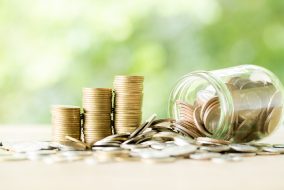 Coin on wooden table in front of green bokeh background. Coin on wooden table in front of green bokeh background. coins a concept of investment and saving moneys.
